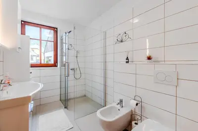 a white bathroom with a sink and a shower at Penzion Hosnar, Apartment Mišc in Bovec