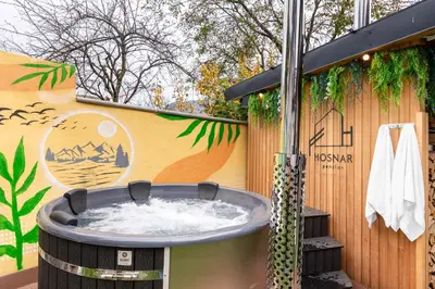 a hot tub in front of a wall with a mural at Penzion Hosnar, Apartment Mišc in Bovec