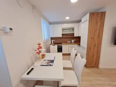 a white dining table and chairs in a kitchen at Studio Apartment Gea 2 Tour As Ljubljana in Ljubljana