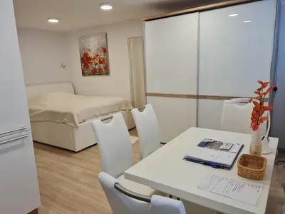 a room with a table and chairs and a bed at Studio Apartment Gea 2 Tour As Ljubljana in Ljubljana