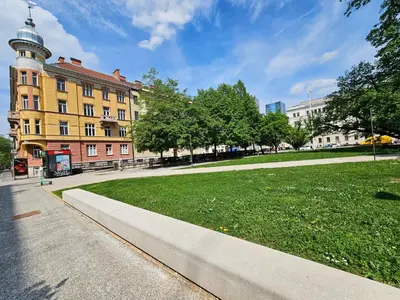 a building with a clock tower next to a park at Studio Apartment Gea 2 Tour As Ljubljana in Ljubljana