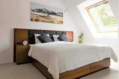a bedroom with a large bed with a window at Zabjak5 in Ljubljana