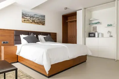 a bedroom with a large bed and a kitchen at Zabjak5 in Ljubljana