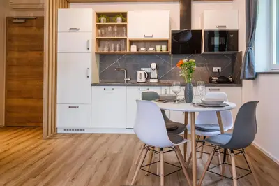 a kitchen with white cabinets and a table and chairs at Vila Rina in Bled