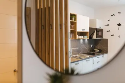 a kitchen with white cabinets and a mirror at Vila Rina in Bled