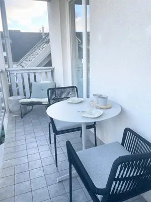 a white table and chairs on a balcony with a table and chairs at Studio XII in Bled