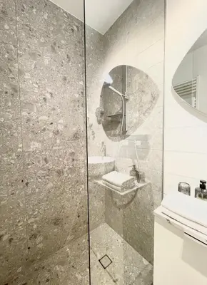 a bathroom with a shower with a toilet and a sink at Studio XII in Bled