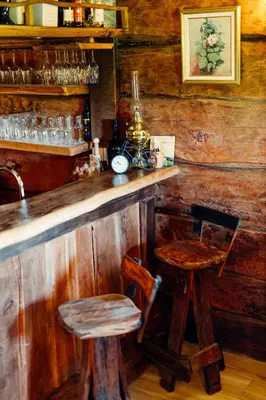 a wooden bar with two chairs and a table at Kmečka hiša Bahor in Črnomelj