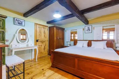 a bedroom with a large bed and a mirror at Kmečka hiša Bahor in Črnomelj