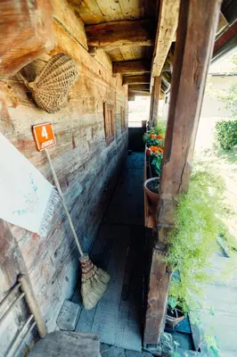 a wooden house with a broom and some plants at Kmečka hiša Bahor in Črnomelj