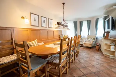 a dining room with a wooden table and chairs at Alpine apartments Marcella in Žirovnica