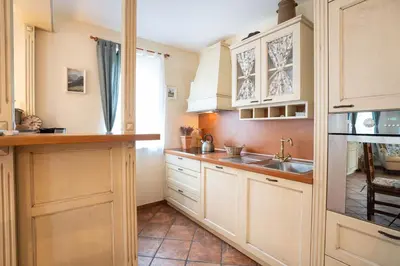 a kitchen with white cabinets and a sink at Alpine apartments Marcella in Žirovnica
