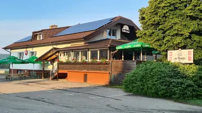 a building with a restaurant on the side of a street at Gostišče pri Rudiju in Šalovci