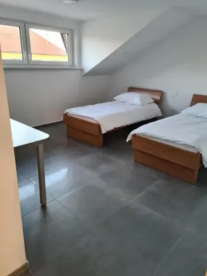 two beds in a room with two windows at Gostišče pri Rudiju in Šalovci