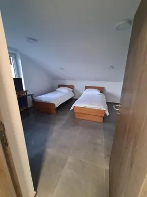 two beds in a room with a door open at Gostišče pri Rudiju in Šalovci