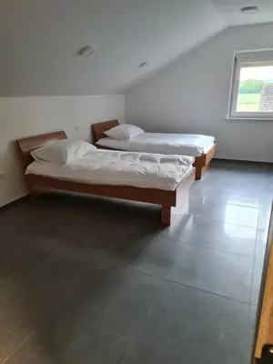 two twin beds in a room with a window at Gostišče pri Rudiju in Šalovci