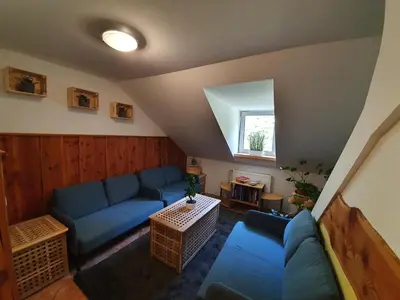 a living room with a blue couch and a table at Pr` Florjan in Cerklje na Gorenjskem