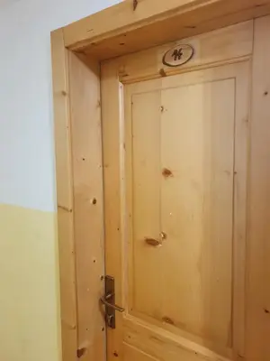 a wooden door with a clock on top of it at Pr` Florjan in Cerklje na Gorenjskem