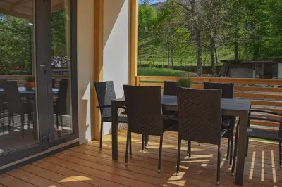 a patio with a table and chairs on a deck at Hiša Uran in Kobarid