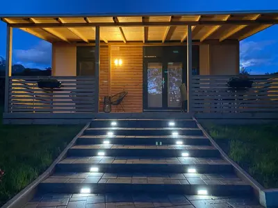 a house with a deck at night with lights at Hiša Uran in Kobarid