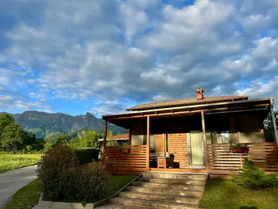 a wooden cabin with a view of the mountains at Hiša Uran in Kobarid
