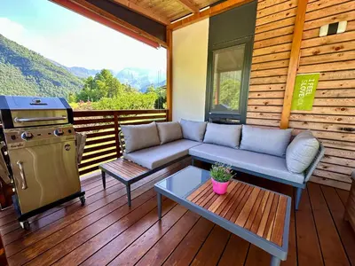 a screened in porch with a couch and a stove at Hiša Uran in Kobarid