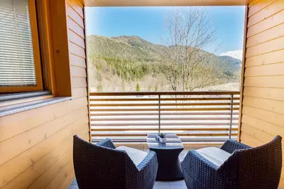 a screened in porch with two chairs and a table at Apartma Svit in Kranjska Gora