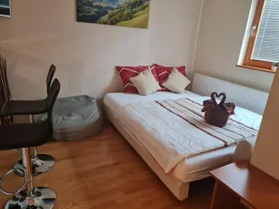 a small bedroom with a bed and a chair at Apartma Svit in Kranjska Gora