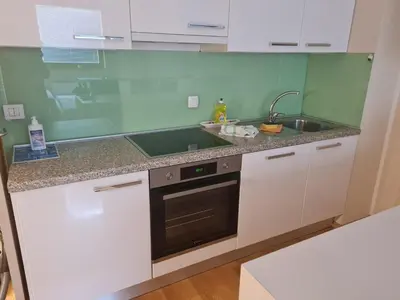 a kitchen with white cabinets and a sink at Apartma Svit in Kranjska Gora