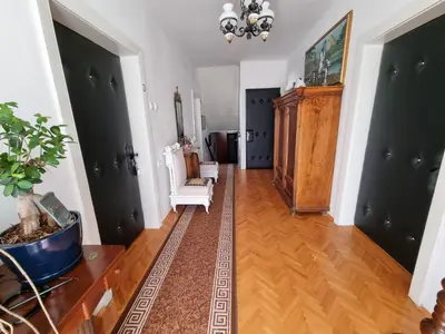 a living room with two white chairs and a wooden floor at Vila Antik in Ilirska Bistrica