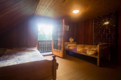 a room with two beds and a window in a cabin at Cottage in the woods - Lake Bohinj in Bohinj