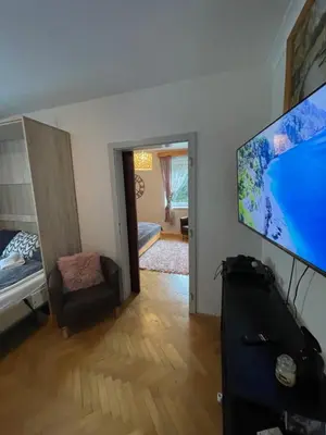 a living room with a flat screen tv and a bedroom at APARTMA ODKLOP Rogla in Lukanja