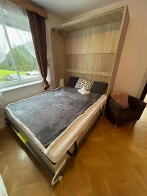 a bed in a room with a large window at APARTMA ODKLOP Rogla in Lukanja