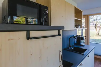 a kitchen with a microwave on top of a counter at Maple & Pine Bled in Bled