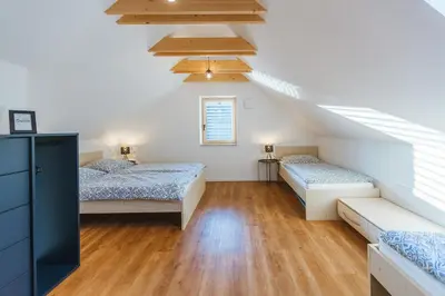 a attic bedroom with two beds and a staircase at Maple & Pine Bled in Bled