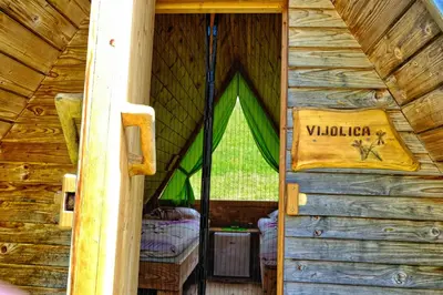 a entrance to a wooden cabin with a window at Glamping Brodej in Vitanje