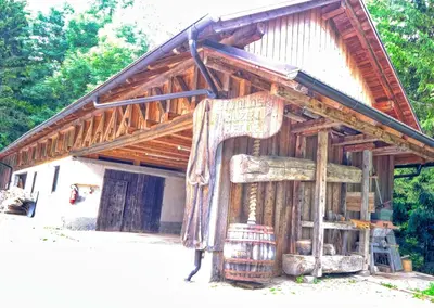 a large wooden building with a barrel in front of it at Glamping Brodej in Vitanje