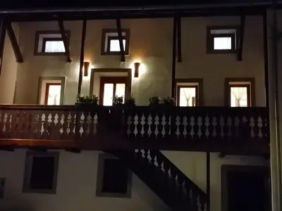 a balcony of a building with windows and a staircase at Hiša pod Gradičem in Kobarid