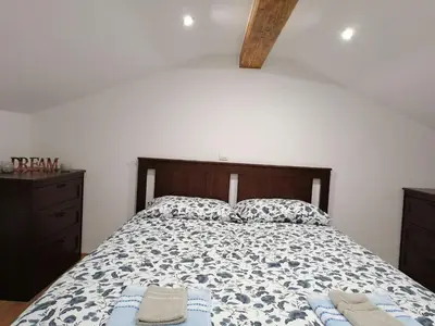 a bedroom with a bed with two towels on it at Hiša pod Gradičem in Kobarid