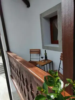 a wooden balcony with a table and a mirror at Hiša pod Gradičem in Kobarid