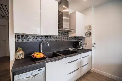 a kitchen with white cabinets and a bowl of fruit on the counter at Apartment Dajana in Bovec