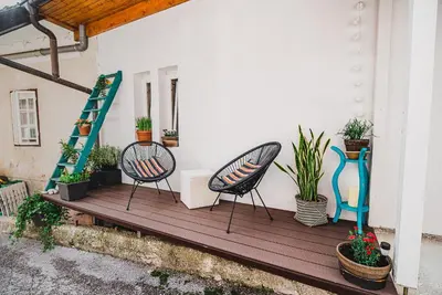a porch with two chairs and potted plants on it at Apartment Dajana in Bovec