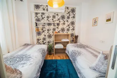 two beds in a small room with a blue rug at Apartment Dajana in Bovec
