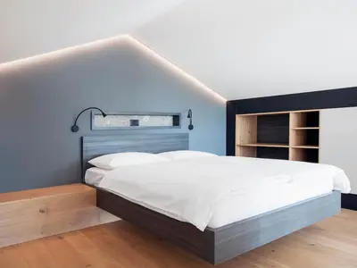 a bedroom with a large bed with a blue wall at Larya House in Dobrovo