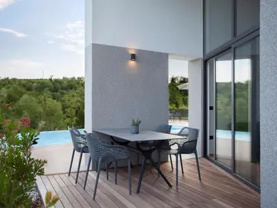 a patio with a table and chairs on a balcony at Larya House in Dobrovo