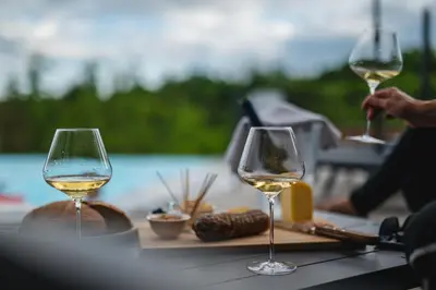 three glasses of white wine sitting on a table at Larya House in Dobrovo