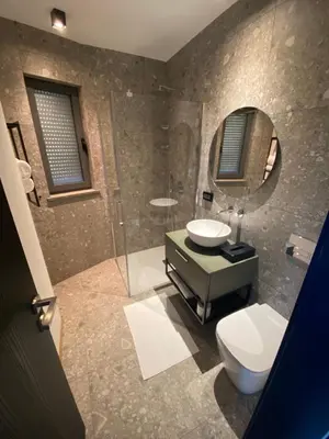 a bathroom with a toilet and a sink and a mirror at Larya House in Dobrovo