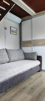 a bedroom with a bed in a room with wood floors at Hiška Čatež in Brežice