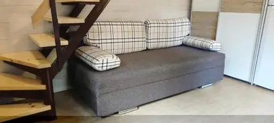 a couch sitting in a room next to a shelf at Hiška Čatež in Brežice