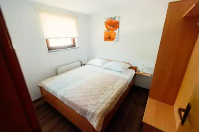 a small bedroom with a bed and a window at Zidanica Bahor in Črnomelj